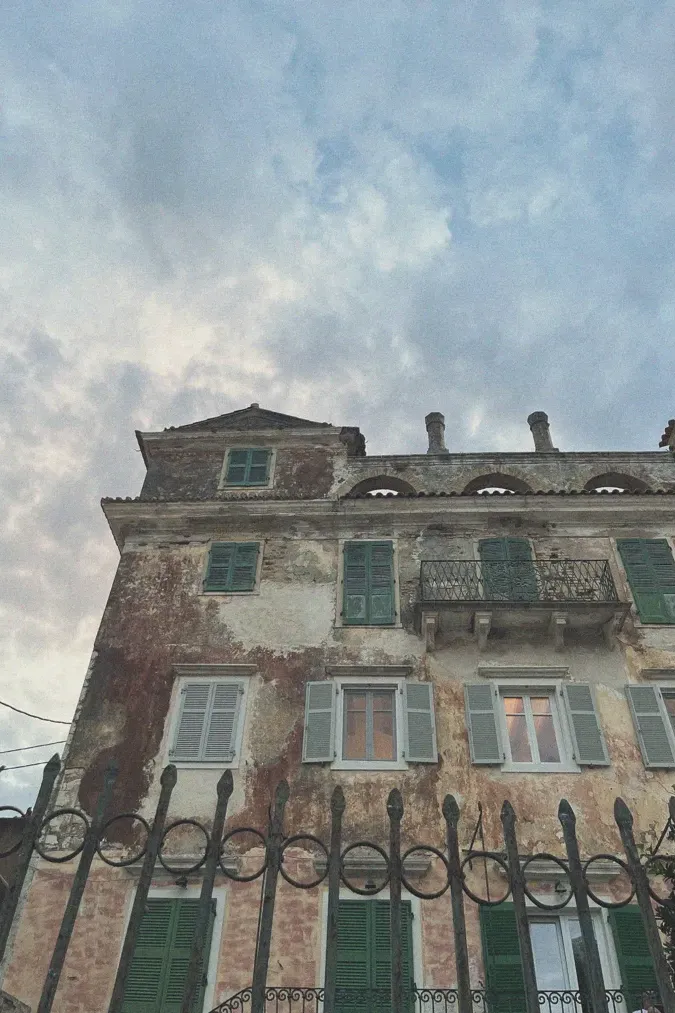 Historic building in Paxos with faded and peeling paint, illustrating the aged beauty and enduring history of the island's architecture.